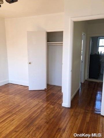 unfurnished bedroom featuring a closet and dark hardwood / wood-style floors