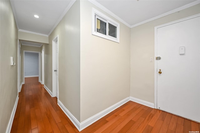 hall with wood-type flooring and crown molding