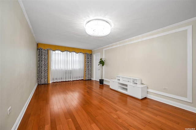 empty room featuring ornamental molding and hardwood / wood-style flooring