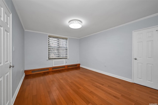 unfurnished bedroom with hardwood / wood-style floors and crown molding