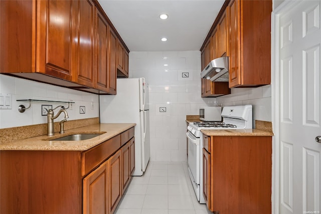 kitchen featuring light stone counters, white appliances, sink, exhaust hood, and light tile patterned floors