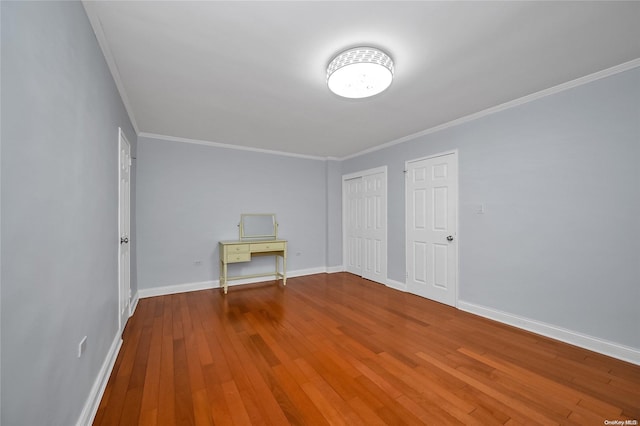 empty room featuring hardwood / wood-style floors and crown molding