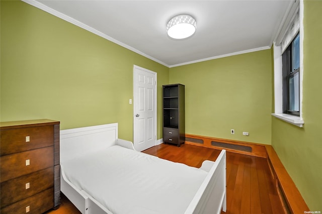 bedroom with hardwood / wood-style flooring and ornamental molding