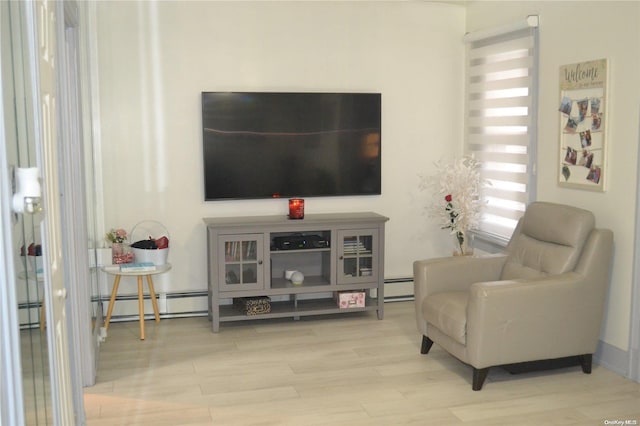 living area with hardwood / wood-style floors and a baseboard heating unit