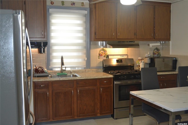 kitchen featuring light stone countertops, sink, decorative backsplash, exhaust hood, and appliances with stainless steel finishes