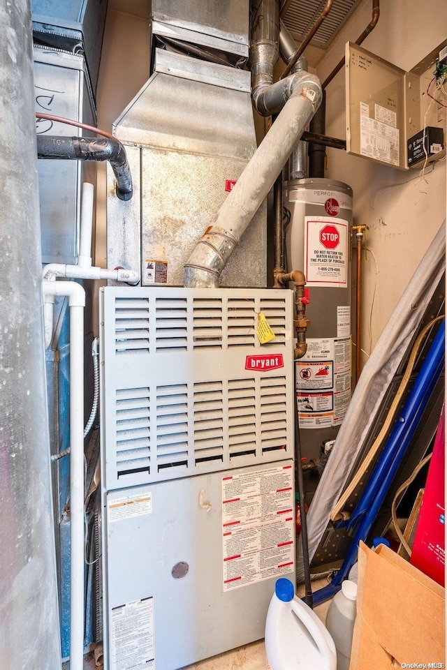 utility room featuring heating unit and gas water heater