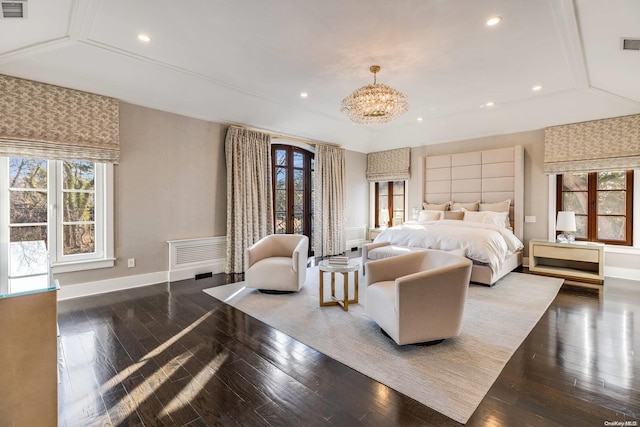 bedroom with dark hardwood / wood-style floors and an inviting chandelier