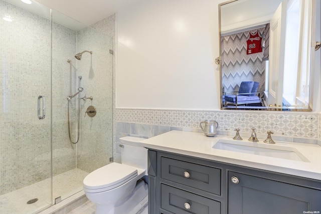 bathroom featuring vanity, toilet, an enclosed shower, and tile walls