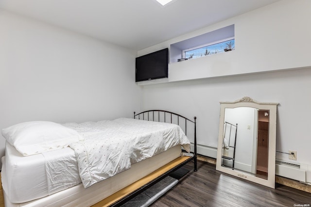 bedroom with dark hardwood / wood-style floors and baseboard heating