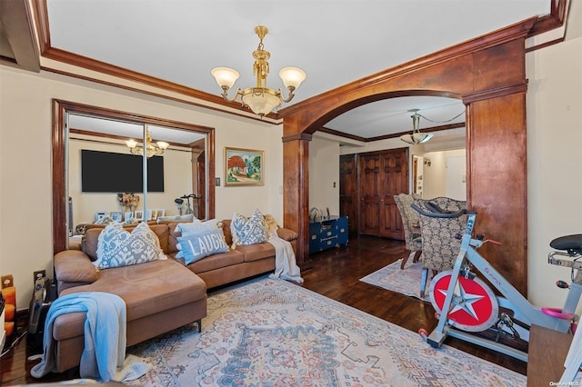 living room featuring a notable chandelier, dark hardwood / wood-style floors, and crown molding