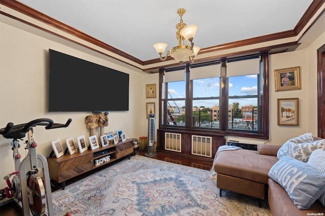 living room with wood-type flooring, crown molding, and a chandelier