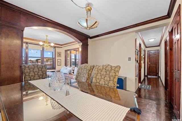 dining space with dark hardwood / wood-style flooring, an inviting chandelier, crown molding, and ornate columns