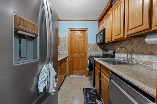 kitchen with light stone countertops, sink, crown molding, decorative backsplash, and appliances with stainless steel finishes