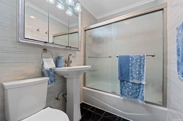 full bathroom with shower / bath combination with glass door, sink, toilet, ornamental molding, and tile walls