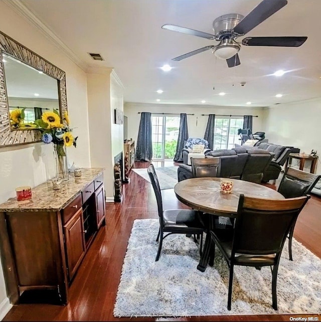 dining space featuring dark hardwood / wood-style floors, ceiling fan, and ornamental molding