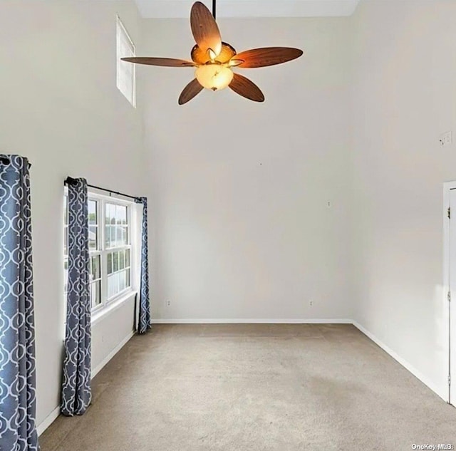 carpeted spare room with ceiling fan