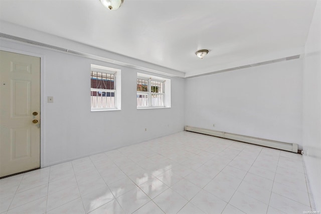 empty room with light tile patterned floors and a baseboard heating unit