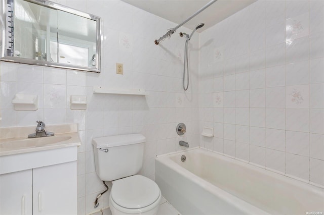 full bathroom featuring tiled shower / bath, vanity, toilet, and tile walls