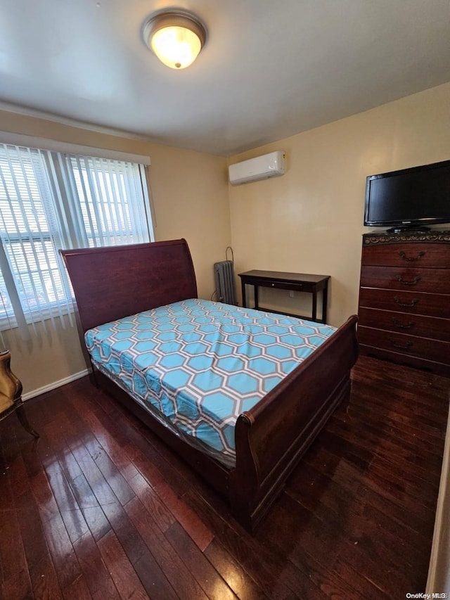 bedroom featuring radiator heating unit, an AC wall unit, and dark wood-type flooring