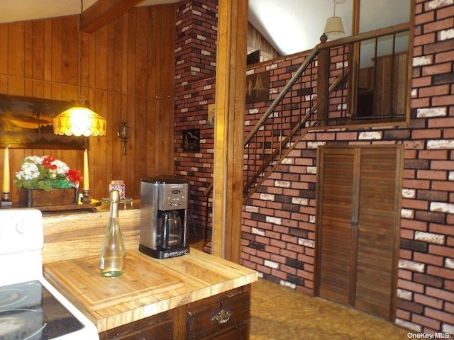 interior space with wood counters, range, brick wall, and wood walls