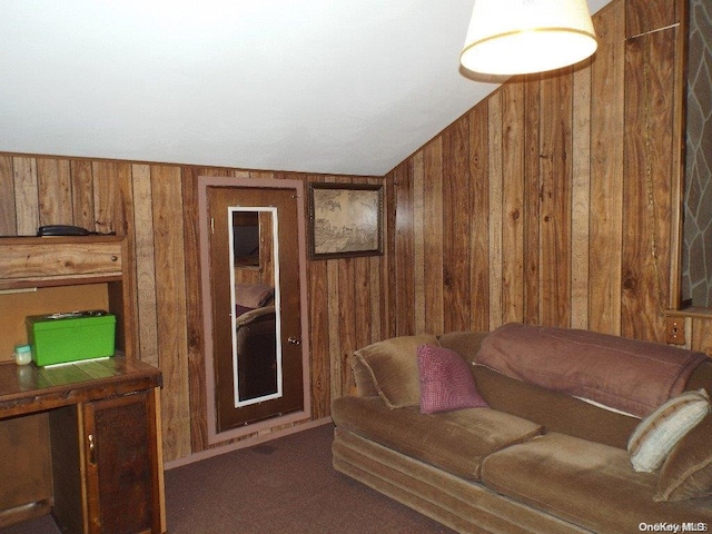 carpeted living room featuring wooden walls and vaulted ceiling