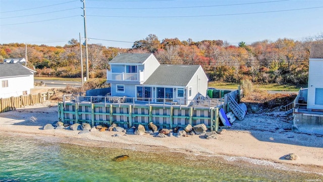 rear view of house featuring a balcony and a water view