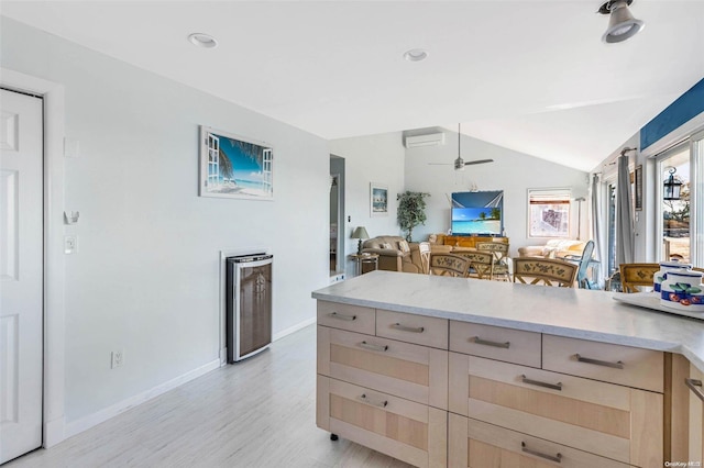 kitchen with ceiling fan, light brown cabinetry, lofted ceiling, and light hardwood / wood-style flooring