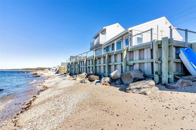 view of building exterior with a water view and a view of the beach