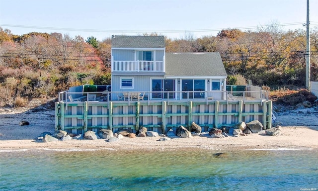 rear view of house featuring a balcony and a sunroom