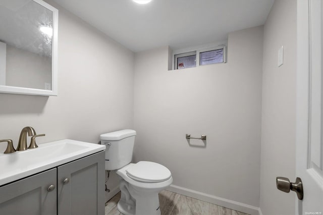 bathroom featuring vanity, hardwood / wood-style flooring, and toilet