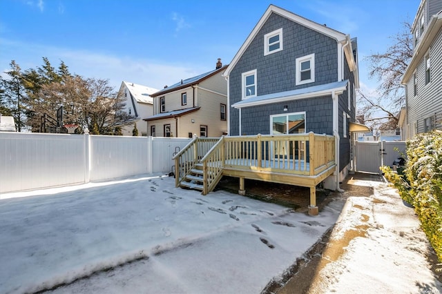 snow covered rear of property featuring a wooden deck