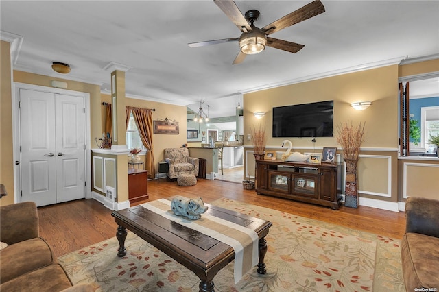 living room with ceiling fan, light wood-type flooring, and ornamental molding