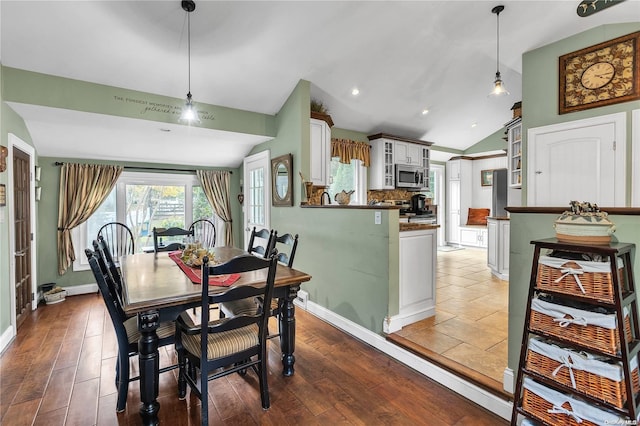 dining area with dark hardwood / wood-style floors and vaulted ceiling