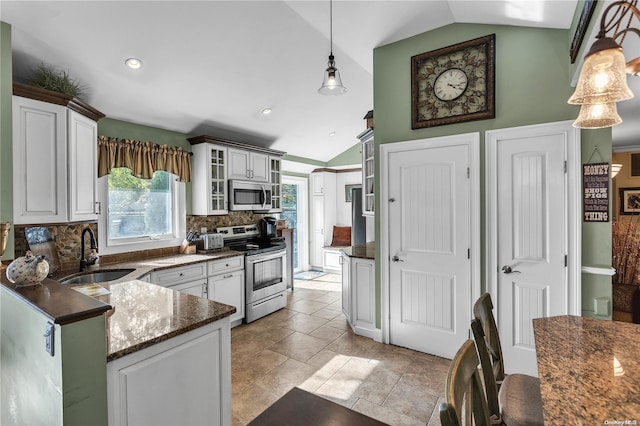 kitchen featuring stainless steel appliances, sink, pendant lighting, white cabinets, and lofted ceiling