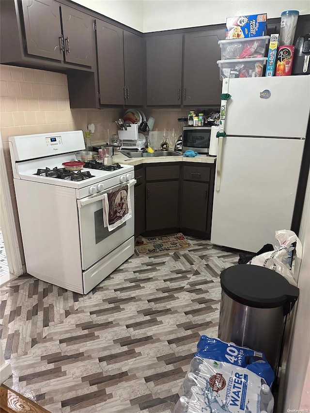 kitchen with backsplash, white appliances, sink, and light hardwood / wood-style flooring