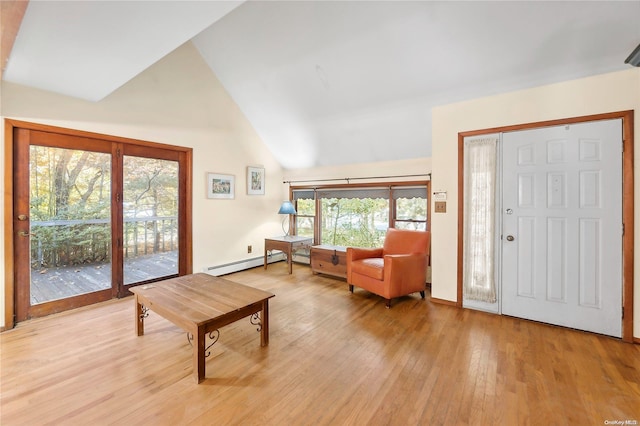 foyer entrance with baseboard heating, high vaulted ceiling, and light hardwood / wood-style flooring