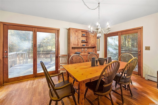 dining room with a chandelier, light hardwood / wood-style floors, and a baseboard radiator