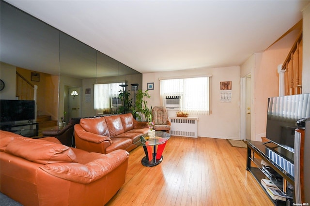 living room featuring radiator, a wealth of natural light, light hardwood / wood-style flooring, and cooling unit