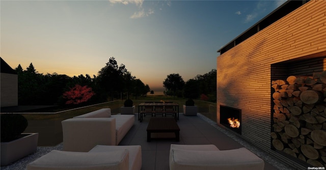 patio terrace at dusk featuring an outdoor living space with a fireplace