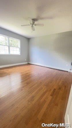 empty room with hardwood / wood-style floors and ceiling fan