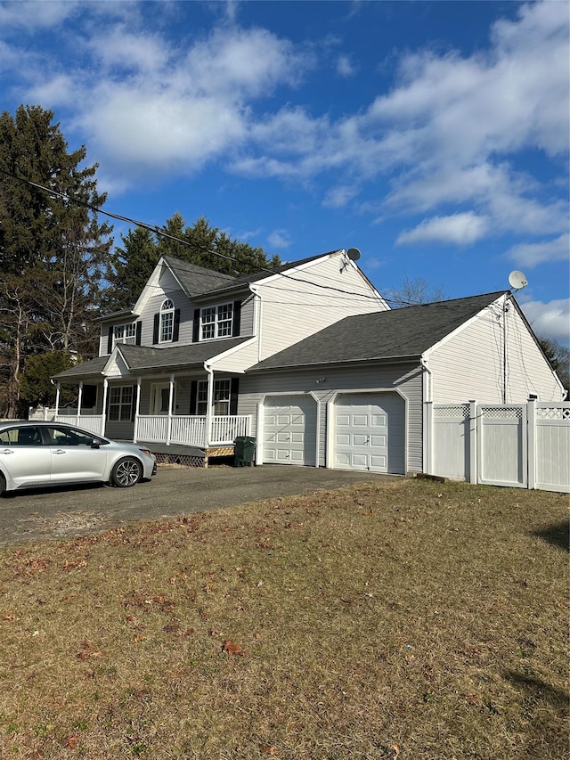 view of front of house with a porch, a garage, and a front lawn