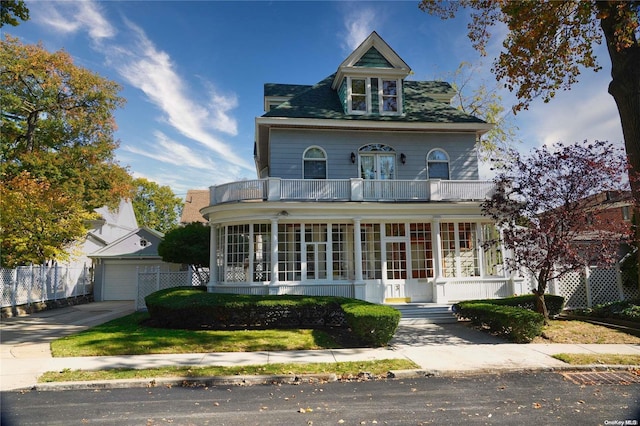 view of front of property with a balcony, an outbuilding, and a garage