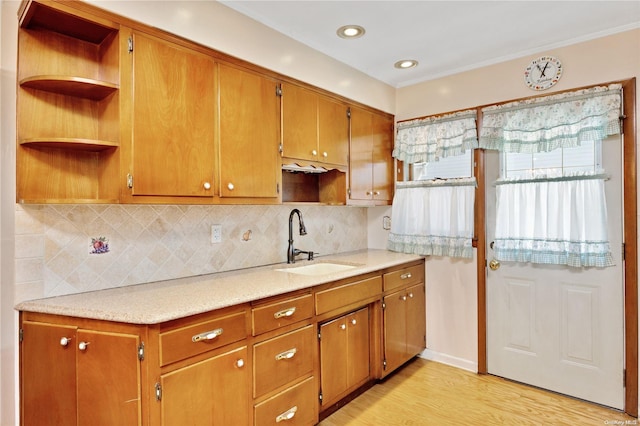 kitchen featuring decorative backsplash, sink, and light hardwood / wood-style flooring