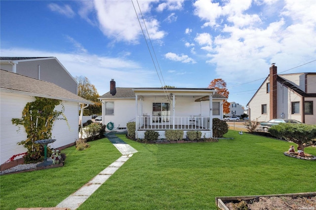 back of property featuring a lawn and covered porch