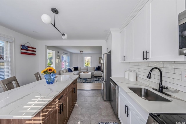 kitchen featuring sink, stainless steel appliances, a kitchen breakfast bar, white cabinets, and light wood-type flooring