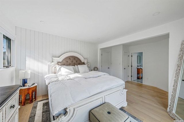 bedroom featuring wood walls and light hardwood / wood-style flooring