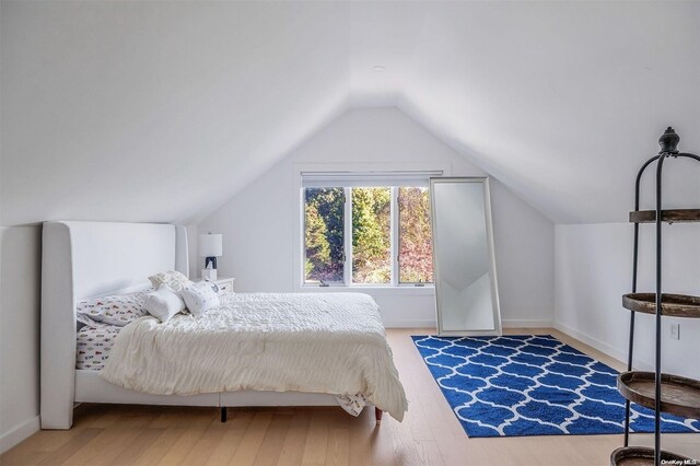 bedroom featuring hardwood / wood-style floors and lofted ceiling