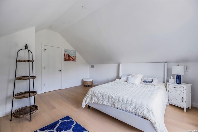 bedroom featuring vaulted ceiling and light wood-type flooring