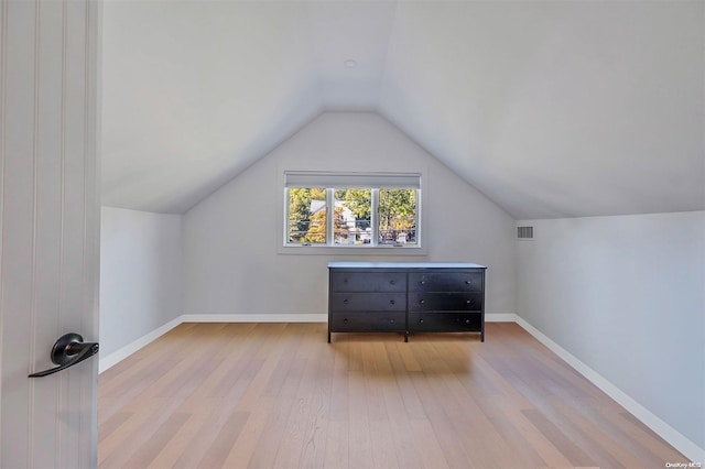 bonus room featuring light wood-type flooring and lofted ceiling