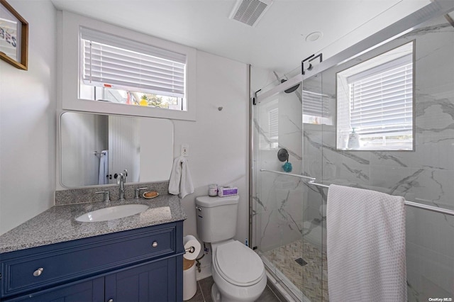 bathroom featuring vanity, toilet, and walk in shower